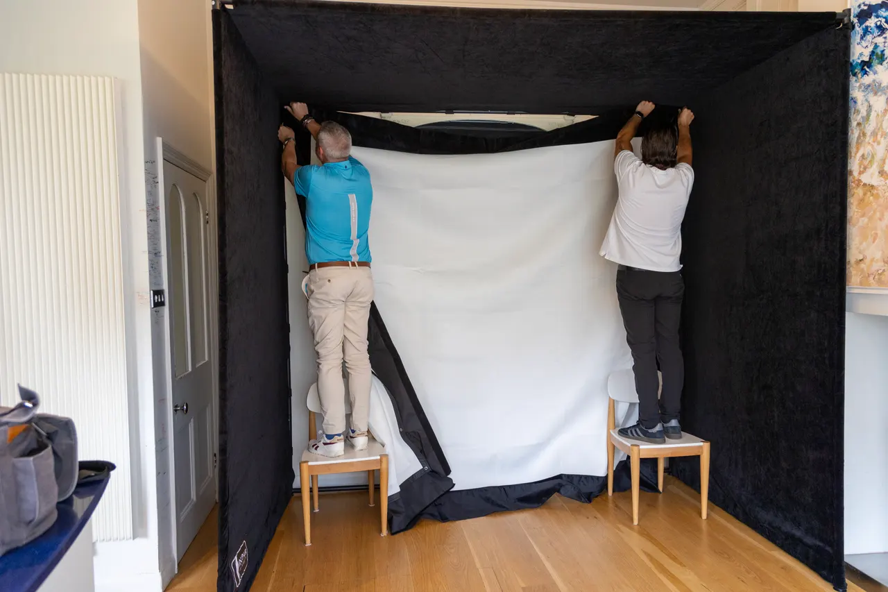 Deux techniciens fixent l'écran d'impact d'une enclosure SimSpace noire